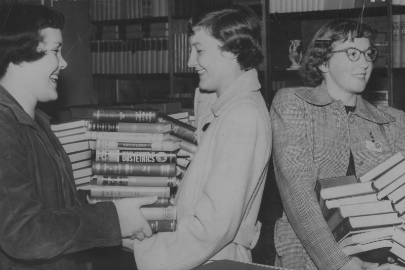 students carrying piles of books-black-and-white undated historic photo